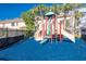 Community playground with slides, climbing structures, and a soft blue surface for safe and enjoyable play for children at 2530 Sandy Beach Ln, Clearwater, FL 33763