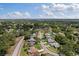 Aerial view of a neighborhood featuring tree-lined streets, well-manicured lawns, and a lake in the distance at 2810 Doone Cir, Palm Harbor, FL 34684