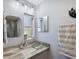 Bathroom vanity featuring granite counters, sleek fixtures, and decorative mirrors at 2810 Doone Cir, Palm Harbor, FL 34684