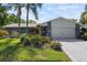 Charming home exterior with mature landscaping, palm trees, and a two-car garage at 2810 Doone Cir, Palm Harbor, FL 34684