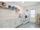Bright laundry room with washer, dryer, utility sink, and ample storage space at 2810 Doone Cir, Palm Harbor, FL 34684