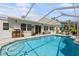 Inviting screened-in pool with ample seating and lush landscaping at 2810 Doone Cir, Palm Harbor, FL 34684