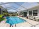 Sparkling pool with screened enclosure and brick pavers offers a delightful outdoor experience at 2810 Doone Cir, Palm Harbor, FL 34684