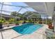 Private screened-in pool with lush landscaping at 2810 Doone Cir, Palm Harbor, FL 34684