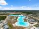 Expansive aerial view showcasing the community lagoon with multiple recreational amenities on a sunny day at 31970 Blue Passing Loop, Wesley Chapel, FL 33545