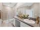 Bathroom with granite countertops, dual sinks, a glass shower, and tile floors for a modern, clean space at 31970 Blue Passing Loop, Wesley Chapel, FL 33545