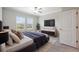 Bright bedroom features large windows, a ceiling fan, and a stylish gray bed with a cozy throw at 31970 Blue Passing Loop, Wesley Chapel, FL 33545