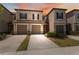 Charming two-story townhome showcasing a two-car garage, neutral color scheme, and beautifully manicured landscaping at 31970 Blue Passing Loop, Wesley Chapel, FL 33545