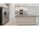 Bright kitchen featuring white cabinets, stainless steel appliances, granite countertops, and a functional center island at 31970 Blue Passing Loop, Wesley Chapel, FL 33545