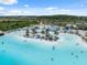 Aerial of a sandy lagoon with lounge chairs, umbrellas and blue water for residents to relax and enjoy at 31970 Blue Passing Loop, Wesley Chapel, FL 33545