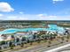 Aerial view of a community lagoon with turquoise water, sandy beaches, and recreational facilities at 31970 Blue Passing Loop, Wesley Chapel, FL 33545