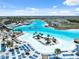 Aerial shot of a lagoon with lounge chairs, umbrellas and blue water with slides for residents to relax and enjoy at 31970 Blue Passing Loop, Wesley Chapel, FL 33545