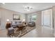 Comfortable living room with neutral tones, tile flooring, large windows, and a stylish decorative rug at 31970 Blue Passing Loop, Wesley Chapel, FL 33545