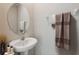 Neat powder room with a pedestal sink, oval mirror, and decorative towels at 31970 Blue Passing Loop, Wesley Chapel, FL 33545