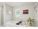 Relaxing bathroom showcasing a soaking tub with a decorative tray and a serene view from the window at 3302 W Beaumont St, Tampa, FL 33611
