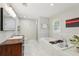 Bright bathroom featuring a wooden vanity, modern fixtures, soaking tub and separate shower with beautiful tile work at 3302 W Beaumont St, Tampa, FL 33611