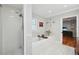 Modern bathroom featuring a separate shower, soaking tub, stylish vanity and decor, leading to a hardwood floor bedroom at 3302 W Beaumont St, Tampa, FL 33611