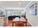 Open-concept dining area with wood floors, modern table, and view into the bright living room at 3302 W Beaumont St, Tampa, FL 33611