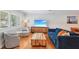 Bright living room with modern decor, hardwood floors, shutters, and a comfortable blue sofa at 3302 W Beaumont St, Tampa, FL 33611
