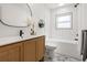 Modern bathroom with decorative vanity, stylish fixtures, sleek white tile and marble-patterned flooring at 3436 Manatee Se Dr, St Petersburg, FL 33705