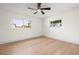 Bright bedroom featuring wood floors, two windows, a modern ceiling fan and fresh paint at 3436 Manatee Se Dr, St Petersburg, FL 33705