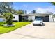 Inviting single-story home featuring a manicured lawn and modern architectural details at 3436 Manatee Se Dr, St Petersburg, FL 33705