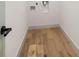 Small, clean laundry area with wood flooring and modern utility connections at 3436 Manatee Se Dr, St Petersburg, FL 33705