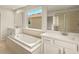 Bathroom featuring dual sinks, white cabinets, a soaking tub, and a separate glass shower at 3472 Timber Crossing Ave, Brandon, FL 33511