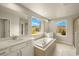 Bathroom featuring dual sinks, white cabinets, a soaking tub, and a separate glass shower at 3472 Timber Crossing Ave, Brandon, FL 33511