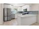 Updated kitchen with white cabinetry, stainless steel appliances, and a chic blue backsplash at 3501 7Th N Ave, St Petersburg, FL 33713