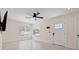Open-concept living room with wood flooring, a white door, and a ceiling fan, providing ample natural light at 3501 7Th N Ave, St Petersburg, FL 33713