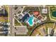 Aerial view of the community pool, splash pad, playground, and community center with a parking lot at 35780 Sunflower Hill Dr, Zephyrhills, FL 33541