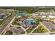 Aerial view of the community center with a pool, playground, splash pad, and nearby pond at 35780 Sunflower Hill Dr, Zephyrhills, FL 33541