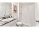 Well-lit bathroom features a granite vanity with a single sink and white tile shower at 35780 Sunflower Hill Dr, Zephyrhills, FL 33541
