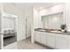 Bathroom with granite double vanity, tile floors, and access to bedroom and shower at 35780 Sunflower Hill Dr, Zephyrhills, FL 33541