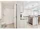 Bathroom with toilet and walk-in shower. Kitchen island with granite counter in background at 35780 Sunflower Hill Dr, Zephyrhills, FL 33541