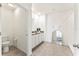 Bright bathroom featuring double sinks, granite counters, toilet, and a walk-in shower at 35780 Sunflower Hill Dr, Zephyrhills, FL 33541