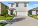 Charming two-story home featuring a well-manicured lawn, inviting curb appeal, and a two-car garage at 35780 Sunflower Hill Dr, Zephyrhills, FL 33541