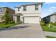 Two-story home boasts a two-car garage, manicured lawn, and charming entryway at 35780 Sunflower Hill Dr, Zephyrhills, FL 33541