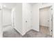 Hallway with gray carpet and white walls leading to various rooms at 35780 Sunflower Hill Dr, Zephyrhills, FL 33541
