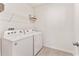 Neat laundry room with modern appliances, wire shelving, and tile floor at 35780 Sunflower Hill Dr, Zephyrhills, FL 33541
