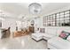 Bright living room with hardwood floors, modern light fixtures, and white couch with floral pillows at 35780 Sunflower Hill Dr, Zephyrhills, FL 33541