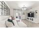 Bright living room with hardwood floors, modern light fixtures, and white couch with floral pillows at 35780 Sunflower Hill Dr, Zephyrhills, FL 33541