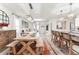 Bright open-concept living room and kitchen with hardwood table, island seating, and modern light fixtures at 35780 Sunflower Hill Dr, Zephyrhills, FL 33541