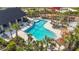 Aerial shot of the community pool and lounging area, surrounded by palm trees, tables and chairs at 35780 Sunflower Hill Dr, Zephyrhills, FL 33541