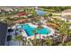 Aerial view of a community pool with palm trees, lounge chairs, tables, and shade canopies at 35780 Sunflower Hill Dr, Zephyrhills, FL 33541