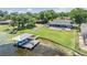 Aerial view of home with pool, boat dock, and large grassy yard extending to waterfront at 3938 Lake Joyce Dr, Land O Lakes, FL 34639