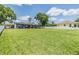 Expansive backyard featuring lush green grass and covered patio with outdoor seating at 3938 Lake Joyce Dr, Land O Lakes, FL 34639
