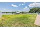 Lush backyard with a picturesque lake view, complete with a charming gazebo and seating area at 3938 Lake Joyce Dr, Land O Lakes, FL 34639