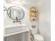 Modern bathroom with a vessel sink, round mirror, and decorative shelf at 3938 Lake Joyce Dr, Land O Lakes, FL 34639